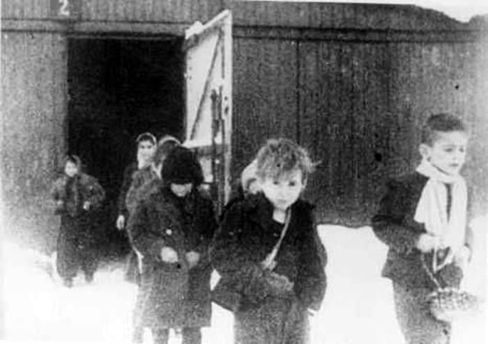 After liberation, surviving children of the Auschwitz camp walk out of the children's barracks. Poland, January 27, 1945