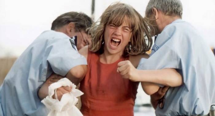 Adele Haenel as Chloé in The Devils (2002), trembling with anguished fury as she struggles against two authorities, her wild hair flying and fist quivering with confusion, a fragile, haunting image of youth’s vulnerability and rage.