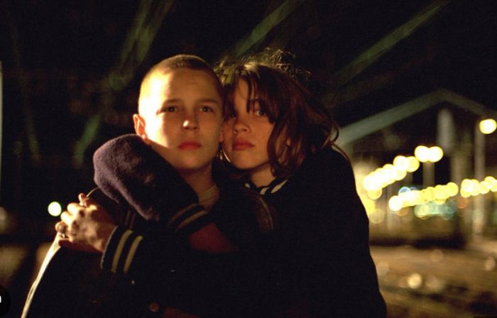 Vincent Rottiers as Joseph and Adèle Haenel as Chloé in The Devils (2002), locked in a tender yet tense embrace under the dim glow of city lights, their faces illuminated by a mix of vulnerability and unspoken longing, hinting at the fragile, ambiguous bond that defines their story.