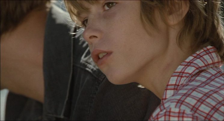Half-hidden beside his older brother Julien (Nicolas Duvauchelle), Louis (Steve Le Roi) watches the chaos of their journey unfold with a quiet, searching gaze that captures the silent loss of his innocence.